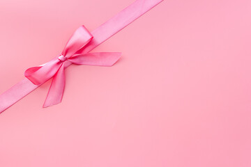 Pink ribbon with bow for holiday gift box or greeting card banner. Top view