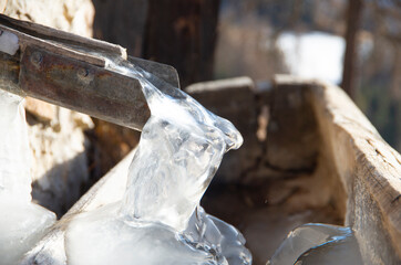 Wooden tap with frozen water jet.