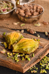 World famous baklava making in Gaziantep. Mussel Baklava presentation on wooden board. The Turkish name of this dessert variety is midye baklava