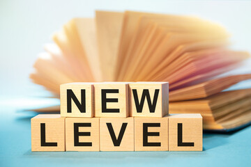 Open book and Wooden cubes with the abbreviation NEW LEVEL