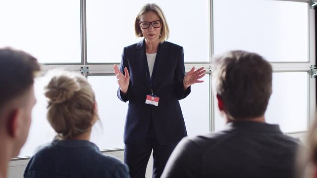 Mature businesswomen giving presentation to colleagues at conference - shot in slow motion