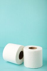 Roll of toilet paper on blue background, top view.