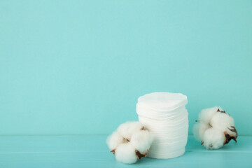 Fototapeta na wymiar Hygienic disposable product cosmetic pads and cotton flower on blue background