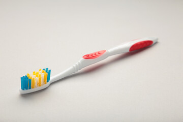 Red toothbrush on a grey background with copy space