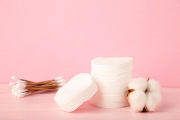 Fototapeta na wymiar Dried white fluffy cotton flower cotton swabs and cotton sticks on a pink background with copy space