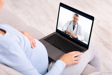 Pregnant Woman Talking With Doctor Via Video Call At Home