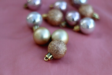 Christmas baubles in pink and gold tones. Selective focus, pink background.