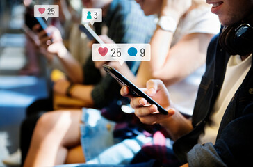 Happy passengers on a subway using social media on their smartphones