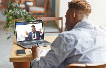 Fototapeta na wymiar Guy attending online training with business coach, listening, taking notes