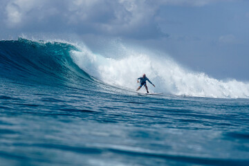 Surfer on perfect blue aquamarine wave, empty line up, perfect for surfing, clean water, Indian Ocean