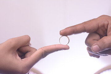 a man's hand inserts a ring on the finger of the bride