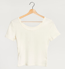 Simple white femat-shirt mockup on a wooden hanger