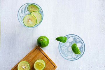 A glass of soda, lemon and lime on the table
