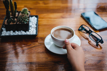 .A cup of coffee on a wooden table in a coffee shop
