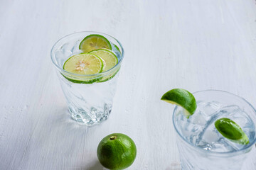 A glass of soda, lemon and lime on the table