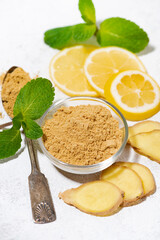 dried and fresh ginger, lemon slices and mint on a white background, vertical top view