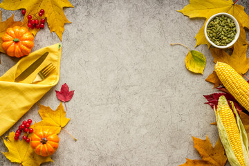 Thanksgiving day dinner table with autumn vegetables and cutlery, top view