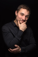 Obraz premium Closeup portrait of handsome man with a beard in black shirt. Isolated on black background