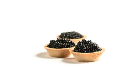 
black caviar on a white plate. tartlet with black caviar. snack.