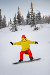 Fototapeta na wymiar Woman is snowboarding on the snowy slopes.
