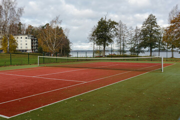 Public tennis court with artificial red turf