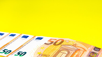 Fragment of the 50 fifty euro banknote on a yellow background. Close up currency money. Copy space for text