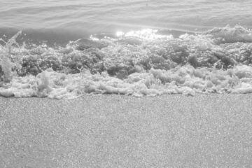 Black and white tone soft wave on sandy beach