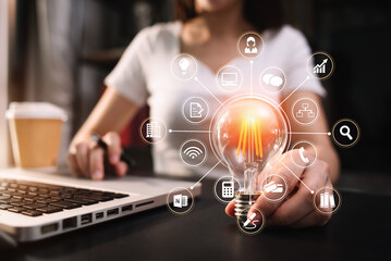 Businessmen who use a laptop and have a light bulb put  concept with innovation and creativity.