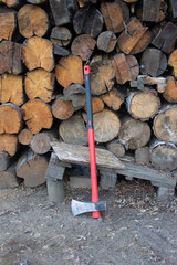 red ax on a background of brown firewood