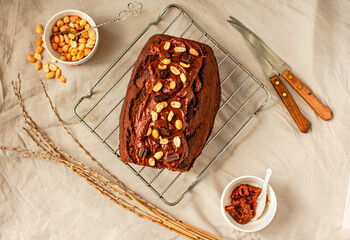 Chocolate Brownies cake with nuts and caramel frosting on wire rack on a light linen cloth. Top...