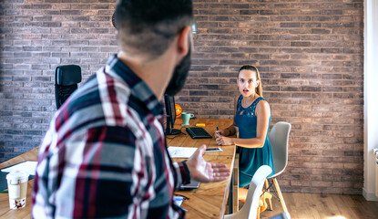 Businesswoman shocked by what her coworker is telling her