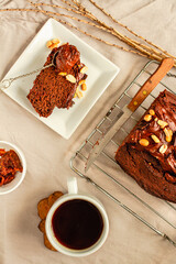 Delicious baked homemade Chocolate cake with nuts and Chocolate cream frosting on wire rack on a linen cloth.Holiday baking concept