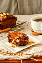 Chocolate cake and slice Spoon with tasty chocolate cream and nuts on on a linen cloth background.Cup of coffee and dessert concept
