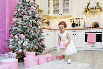 little child girl staying in the kitchen decorated for Christmas 