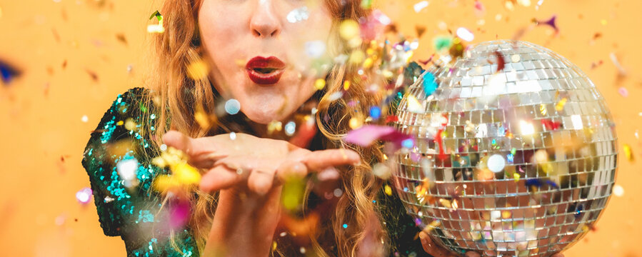 Happy fashion girl blowing confetti holding vintage disco ball - Party concept - Focus on mouth