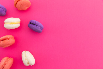High angle view of purple, pink and white macarons on pink background