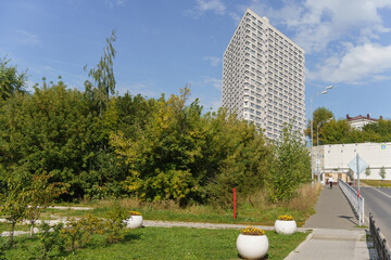 view from the city park to the triangular futuristic skyscraper. High quality photo