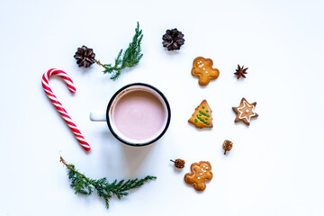 Obraz na płótnie Canvas Eine Tasse heiße Schokolade mit selbstgemachten Lebkuchen Keksen und einer roten Zuckerstange auf einem weißen Hintergrund. Flat lay, Weihnachten.