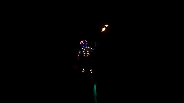 Spectacular night show on the water. A flyboarder with a flamethrower flies over the sea.