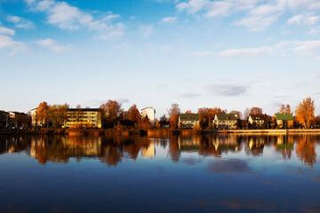 houses reflected in the river water in autumn