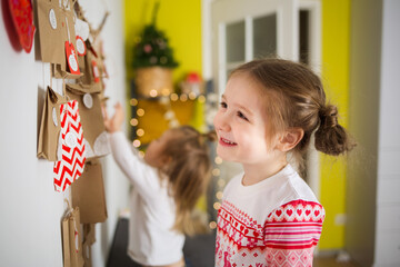 advent calendar for kid. children in red christmas pajamas. portrait of happy girl