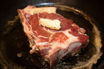 frying meat in a pan with boiling oil