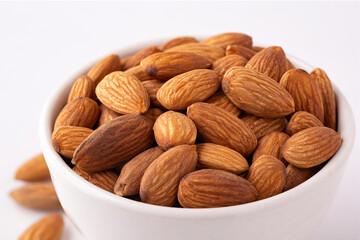 Close-up of fresh raw almonds on a white background