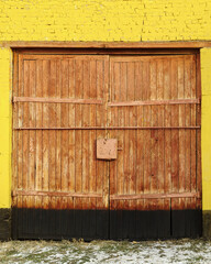 Wooden gate in a yellow brick wall. The picture was taken in Russia, in the city of Orenburg