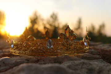 mysterious and magical photo of gold king crown in the England woods over stone. Medieval period concept.