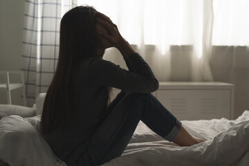 Suffer from depression , mental health problem. asian young woman sitting on the bed feeling...