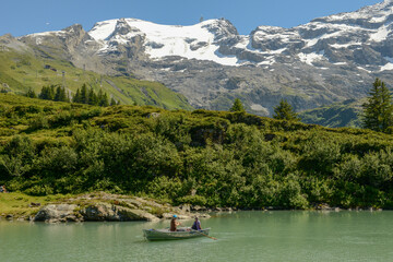Tourists rowing in their boat at lake Truebsee above Engelberg on the Swiss Alps
