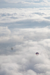 Two hot air balloons in the clouds