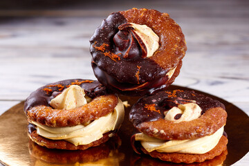 Three homemade chocolate covered marshmallow crackers (s'more ) on a round gold-plated stand plate.