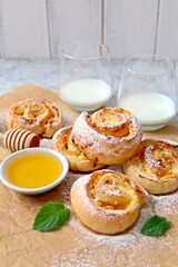 Sweet puff pastry roll for breakfast or snack served with honey and milk. Top view with copy space. Healthy food.